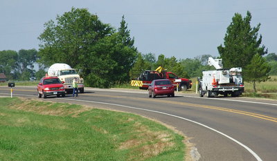 Image: You can see here how the situation intensifies for rescuers, police and firefighters whenever traffic control becomes a factor as Chief Chambers (located to the left in this photo) juggles the safety of his fire crew, the Oncor utility driver who has just arrived on scene, a passing propane truck and motorist.