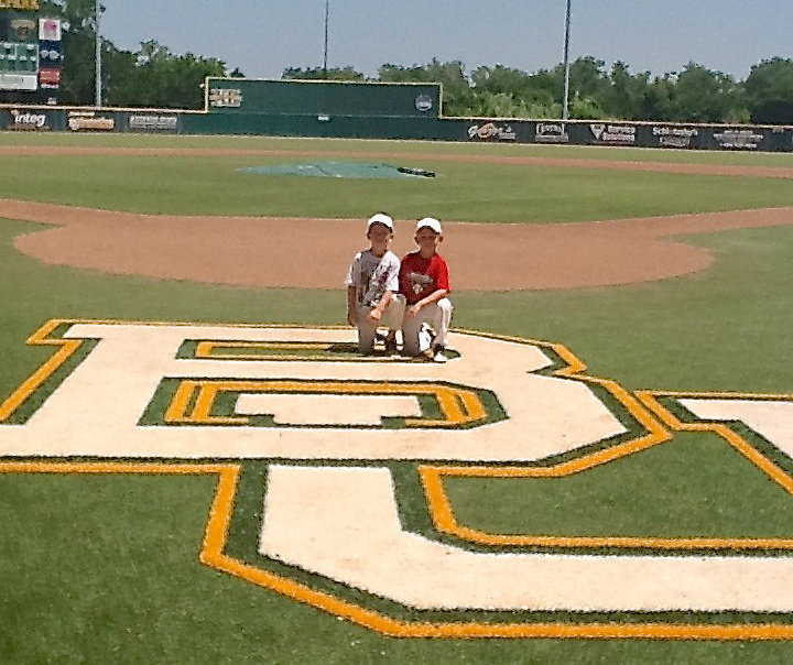 Image: Austin Cate, 7 with friend and teammate Dustin Duke, 7, represented Italy and the IYAA Sports Family (Italy Youth Athletic Association) during a summer baseball camp held at Baylor University. Despite being the youngest campers in attendance, Cate and Duke left their mark on Baylor’s baseball field.