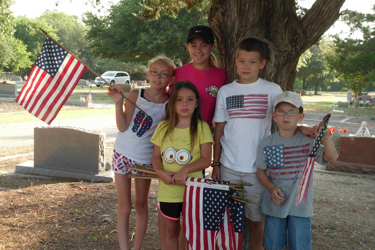 Image: Italy youth help place flags on veterans graves at the Italy Cemetery.