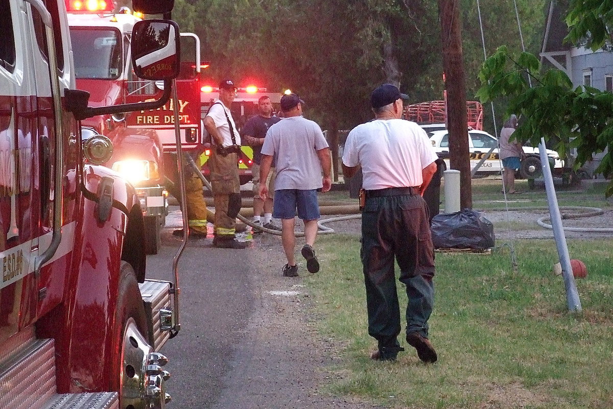 Image: Italy Fire Chief, Donald Chambers, and fellow firefighter, Jackie Cate, monitor the scene of the early morning porch fire that resulted from embers escaping from a grill used the night before.