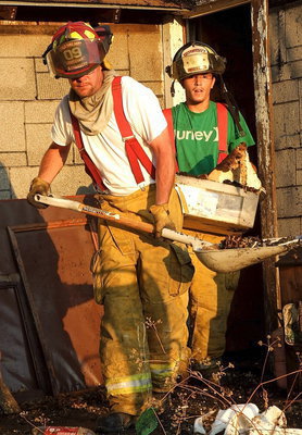 Image: Italy firefighters, Brad Chambers, and Brandon Jacinto, remove burnt debris from the interior of the home.