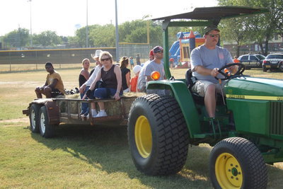 Image: A hay ride gives fans from the community a lift to the ball field after parking was confined to the field house which allowed the kids freedom to play and stay safe.