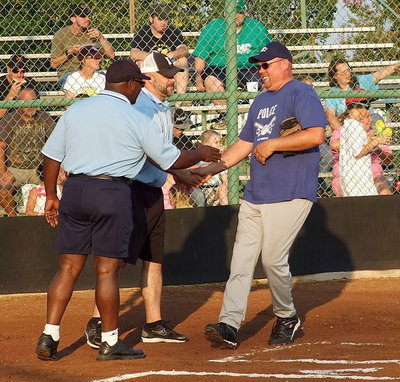 Image: Italy Police Chief Diron Hill greets umpires Robert Hodge and Lee Joffre during the pre-game introductions.