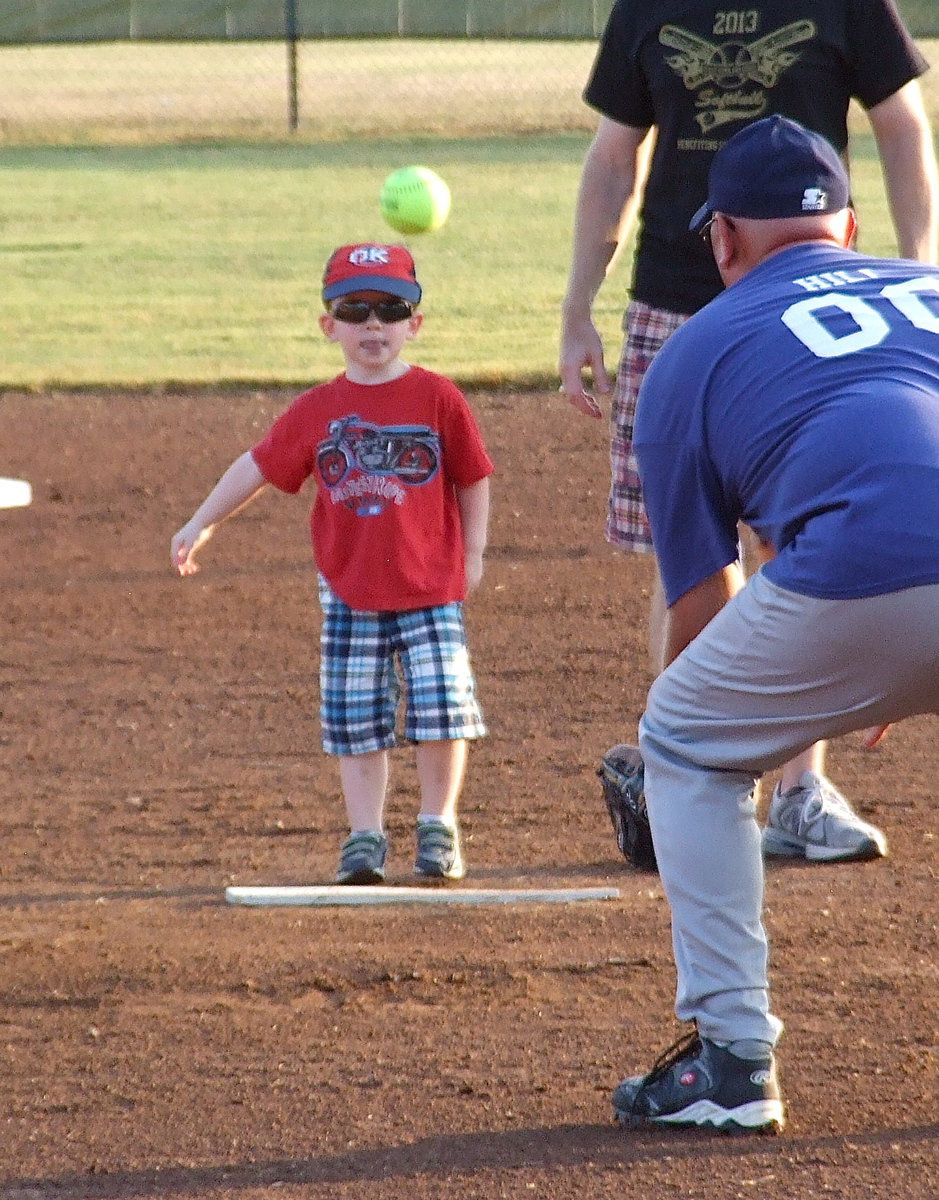 Image: Italy Police Chief Diron Hill catches the game’s opening pitches from Ellis County District Attorney Patrick Wilson and his son.