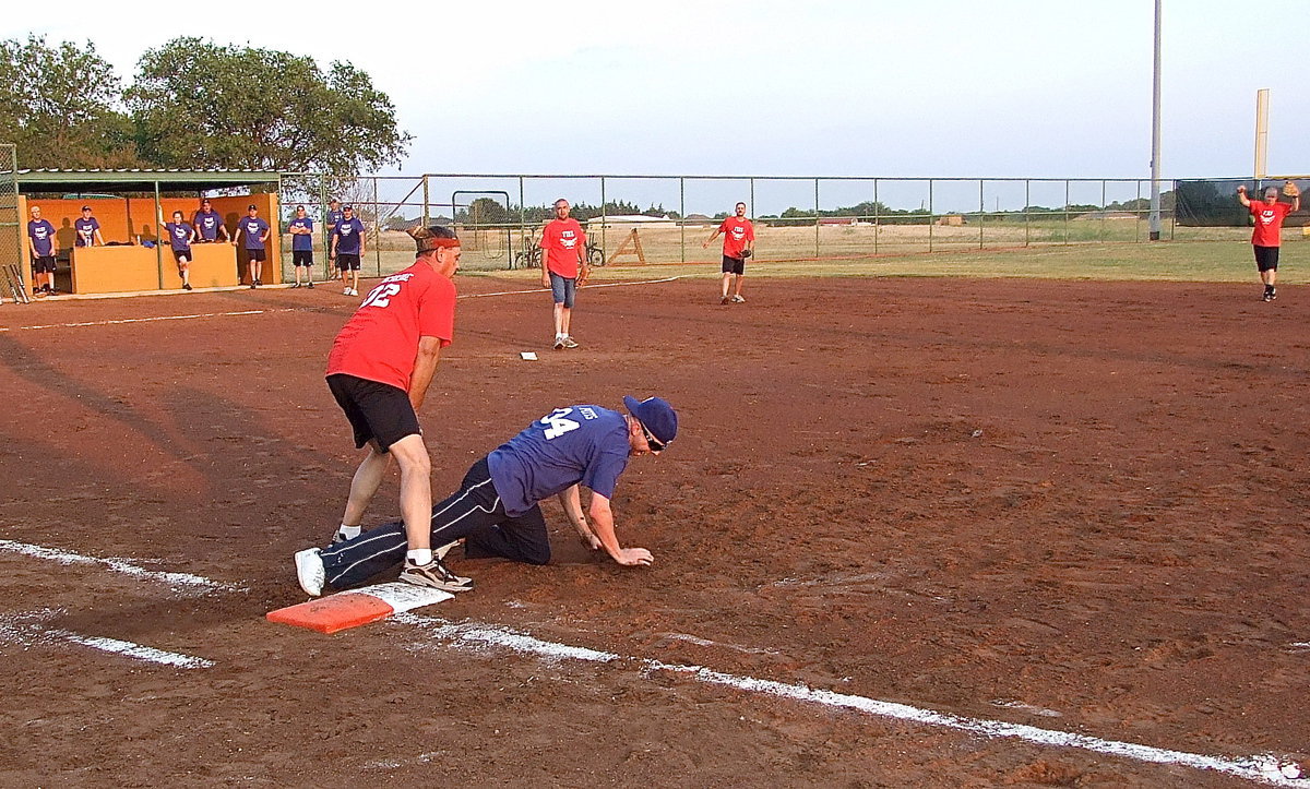 Image: Firefighter Bobby McBride makes the tag to get copper Daniel Pitts out at first base.