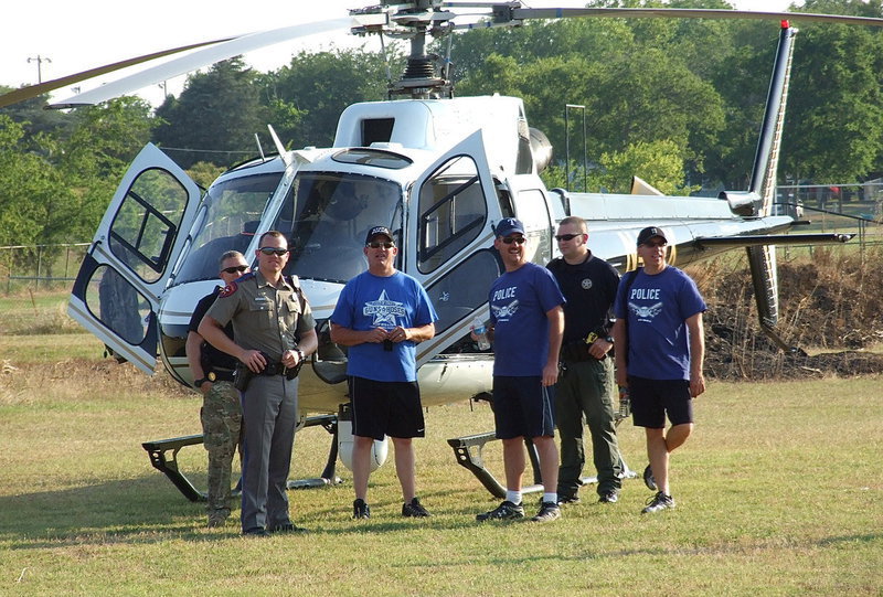 Image: The ‘Helicops’ land in the outfield before the start of the Guns vs. Hoses softball game. The community was allowed to examine the inside of the copter.