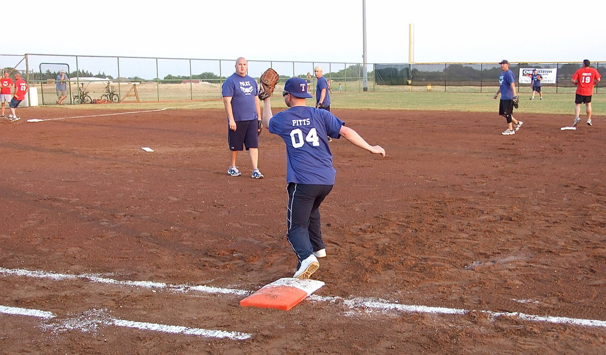 Image: Firefighter Brad Chambers reaches third base and teammate Justin Roberts makes it to second but Officer Daniel Pitts makes the catch for an out at first base.