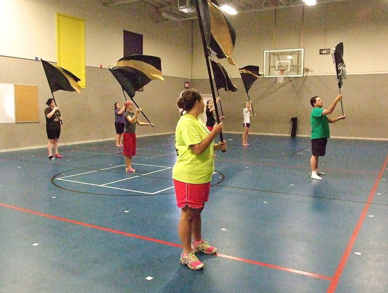 Image: IHS Color Guard sponsor Amber Droll joins the group for a routine.