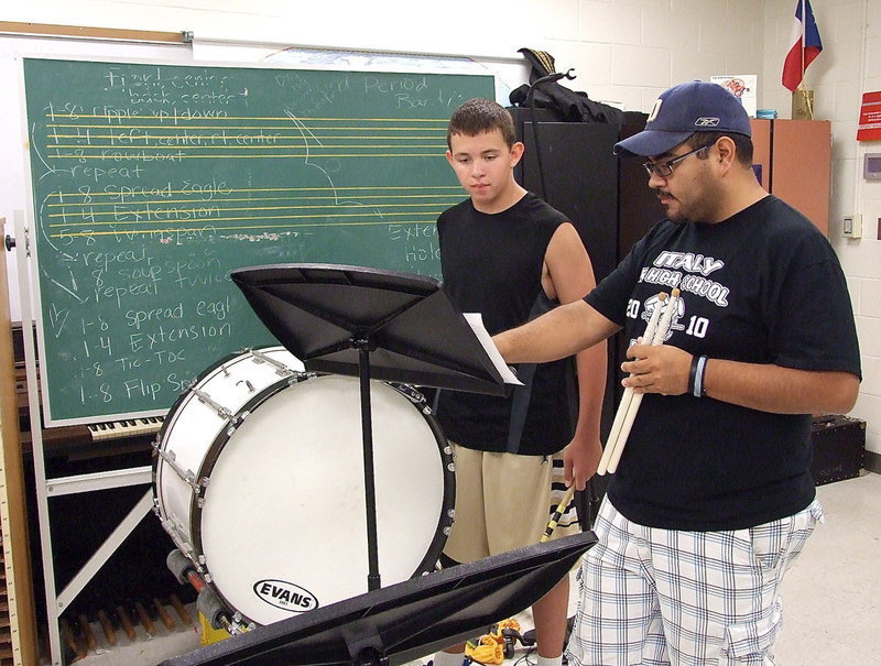 Image: Band instructor Jesus Perez assists Austin Crawford with interpreting a line of notes on the final day of band camp held at Italy HS.