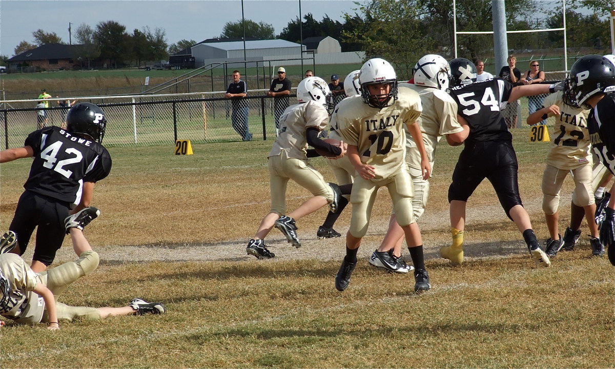 Image: Italy’s A-Team quarterback Ryder Itson(2) sweeps left behind his blockers.