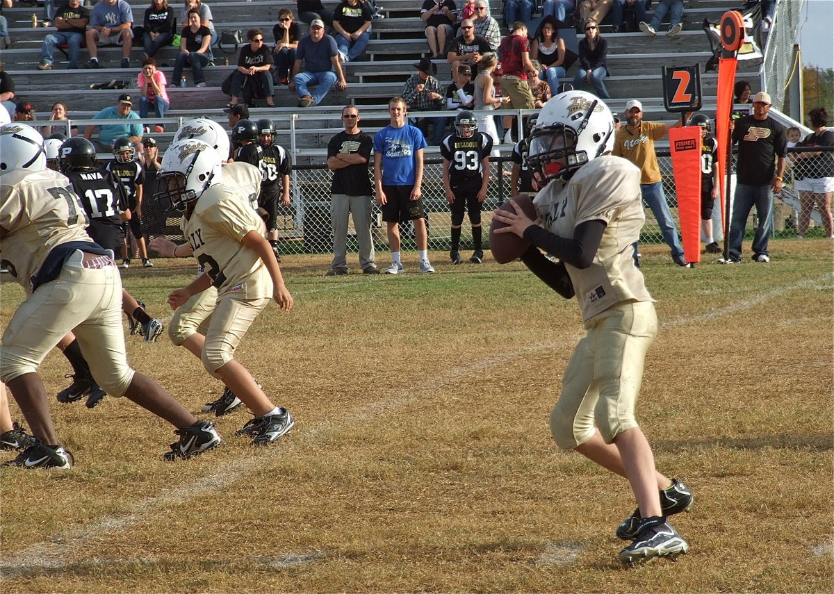 Image: Ryder Itson(2) looks for an open receiver as Anthony Lusk(75) and Michael Gonzalez(12) buy Itson time in the pocket.