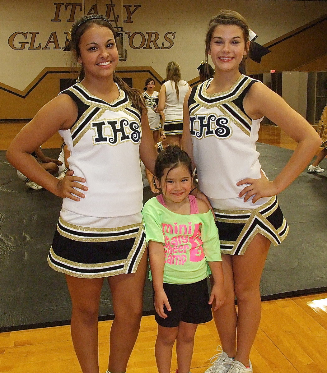 Image: Varsity cheerleaders Ashlyn Jacinto and Kristian Weeks pose with happy camper Halee Carr.