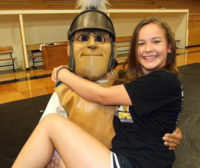 Image: A gallant Gladiator gives cheerleader Paige Little a lift.