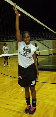 Image: Above the volleyball net without leaving the floor is Lady Gladiator Janae Robertson.