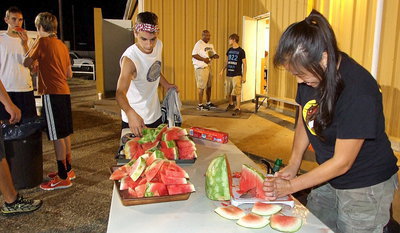 Image: Nicole Tindol, wife of Charles Tindol, serves up watermelon to the players upon conclusion of Midnight Madness.