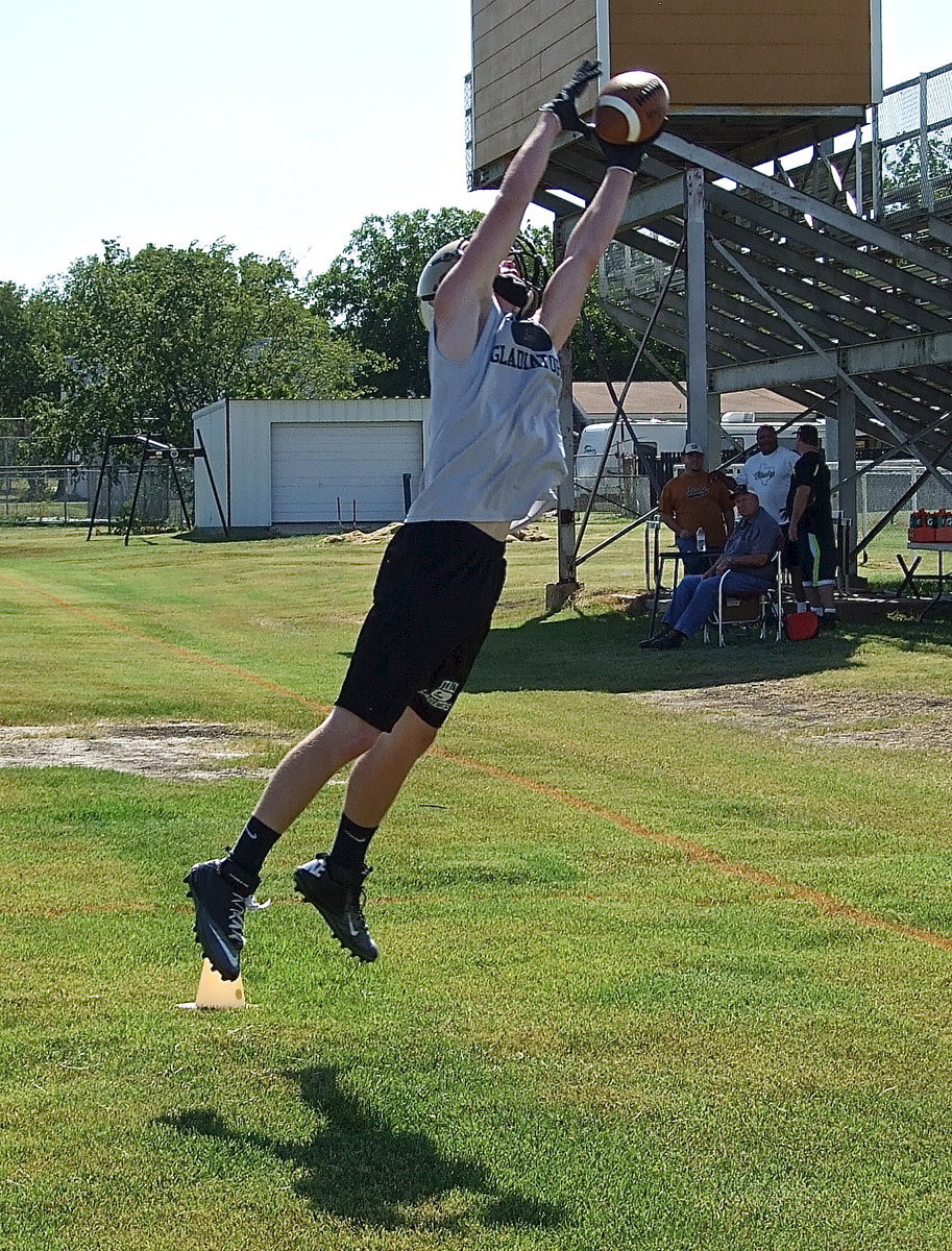 Image: Junior Gladiator Cody Boyd stretches for an interception during an Oskie drill during 2-a-day workouts.