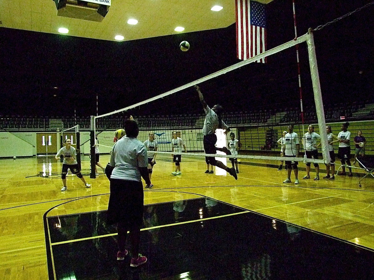 Image: Junior middle hitter Kortnei Johnson takes flight during a practice session.