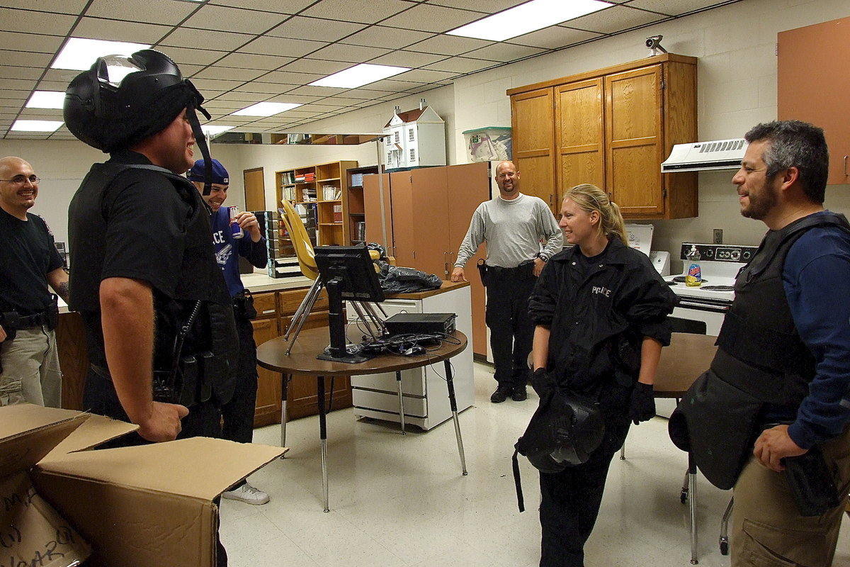 Image: Officers share a light moment before the intensity picks up during a rescue simulation drill.