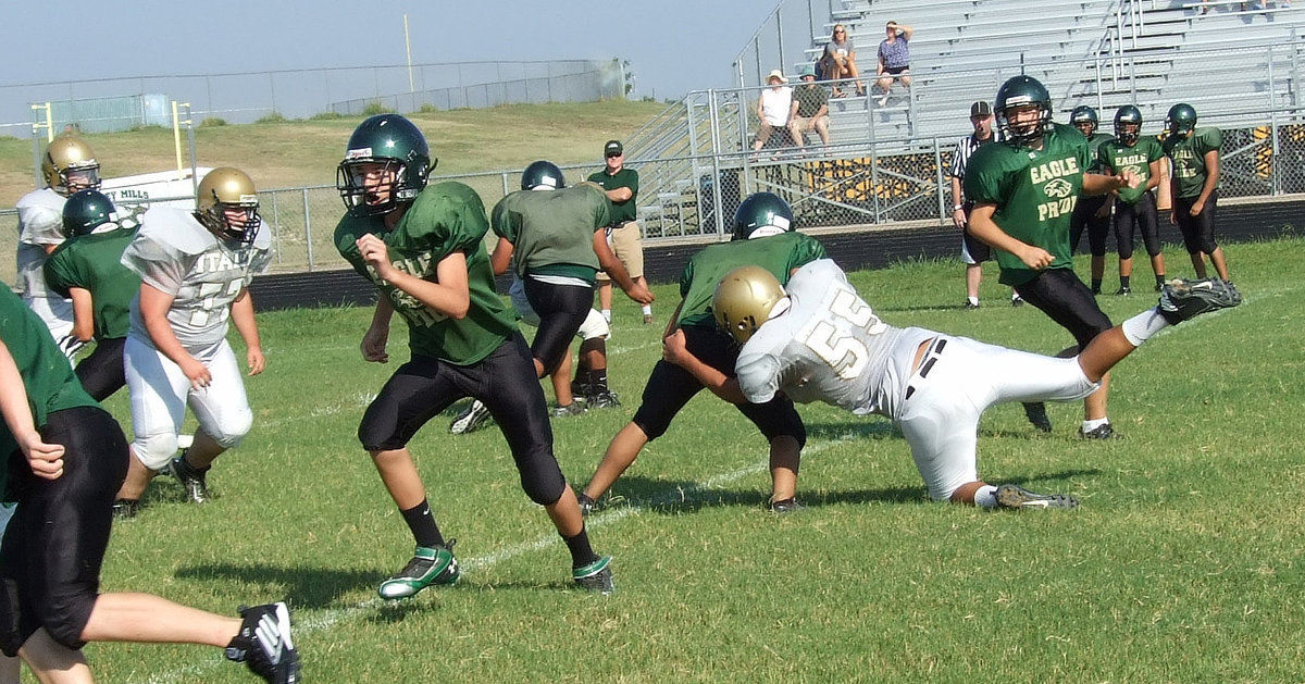 Image: Freshman JV Gladiator David De La Hoya(55) attacks the Valley Mills quarterback with teammate Samuel Corley(77) on his way to help bring down the stubborn Eagle passer.