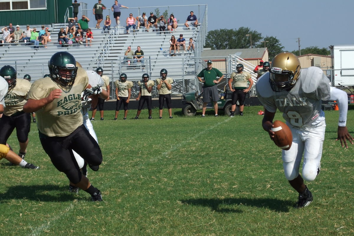 Image: Italy senior quarterback Tamarcus Sheppard(8) escapes pressure from Eagle defenders proving he can guide the Gladiator offense by air or by ground.