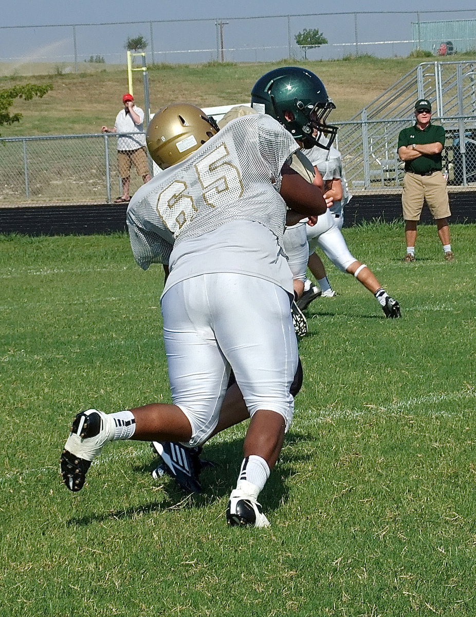 Image: All-District last season, offensive tackle Darol Mayberry(65) keeps blocking an Eagle defender as the play develops.