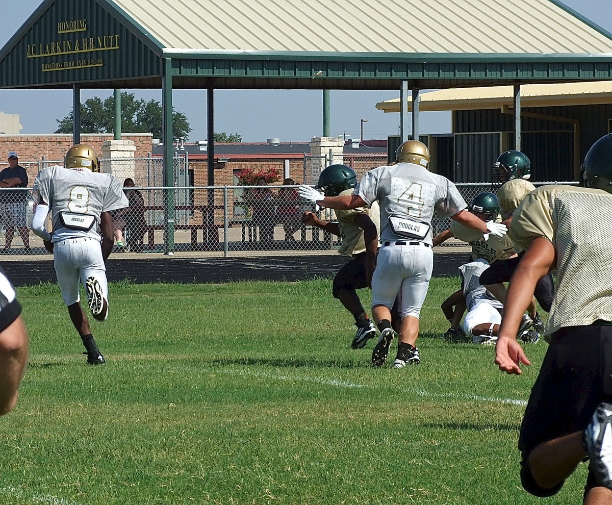 Image: Italy’s Tamarcus Sheppard(8) receives blocks from Trevon Robertson(1) and Shad Newman(4) to get the edge and run in for 1 of his 4 touchdowns during the scrimmage.