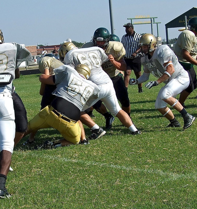 Image: Zain Byers(60) and Kevin Roldan(50) combine to halt the progress of the Eagle’s offense as Roldan brings the runner down.