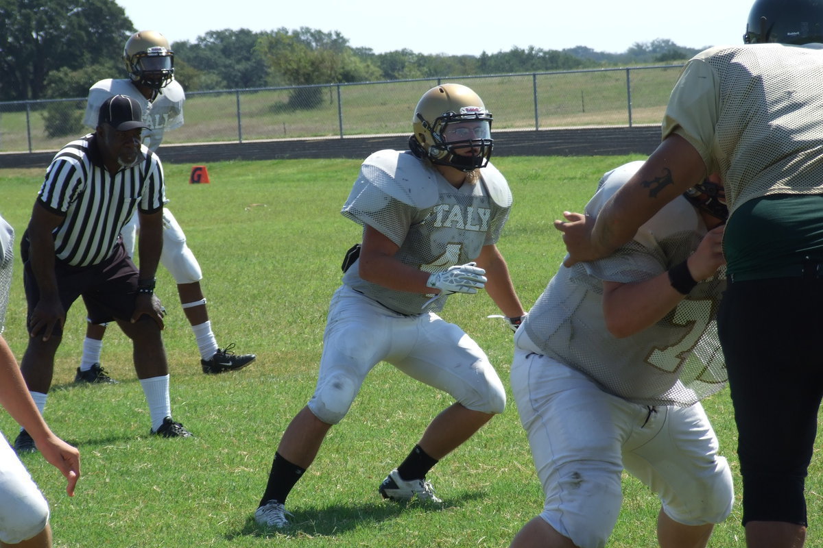 Image: Italy linebacker Shad Newman(4) reacts to the play with John Byers(72) staying low in the trenches and safety Trevon Robertson(1) backing them up.