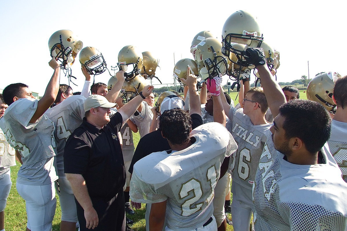 Image: Italy’s assistant coach, Wayne Rowe, tells his JV Gladiators to hoist their golden victory bonnets high because they not only carry their team on their shoulders, they carry their town.