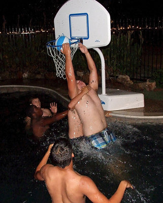 Image: Kevin Roldan says, “Take that,” as he reverse slams over school mates during water basketball.