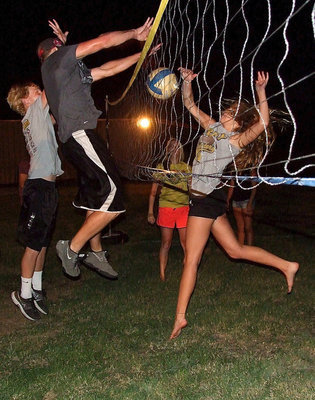 Image: Cody Boyd and Coby Bland have their hands full as does Lady Gladiator volleyball player Halee Turner as the three up the tempo in a casual game of take it easy volleyball.