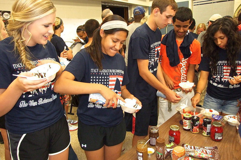 Image: Annie Perry, Marlen Hernandez, Ryan Connor, Jorge Galvan and Julissa Hernandez attempt to operate the CoolWhip can as the ice cream part of the Band’s Social gets underway inside the band hall.