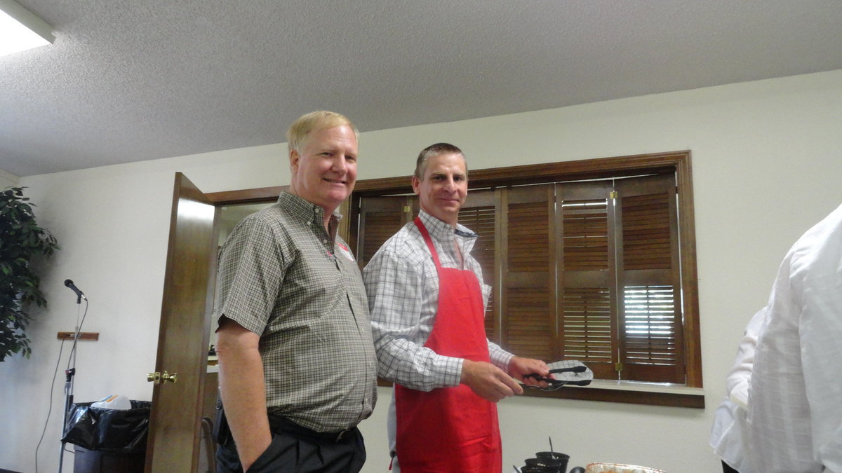 Image: Curtis Riddle is busy serving guests while visiting with George Morgan.