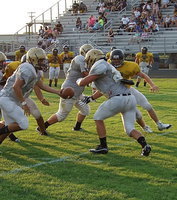 Image: Backup quarterback Tyler Anderson(11), a senior, hands off to Shad Newman(24).