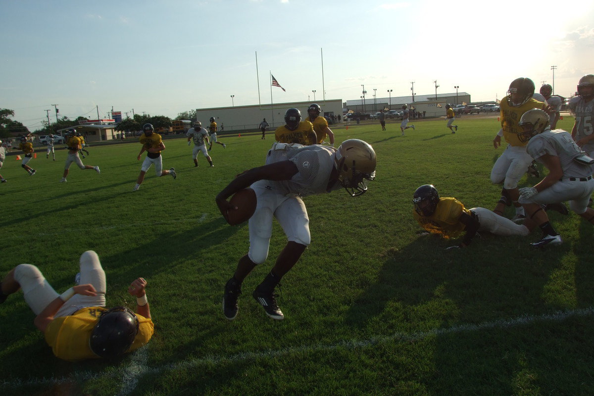 Image: Twisting out of a tackle and then reversing his field for one of the longest runs of the scrimmage is Gladiator quarterback Tamarcus Sheppard(12).