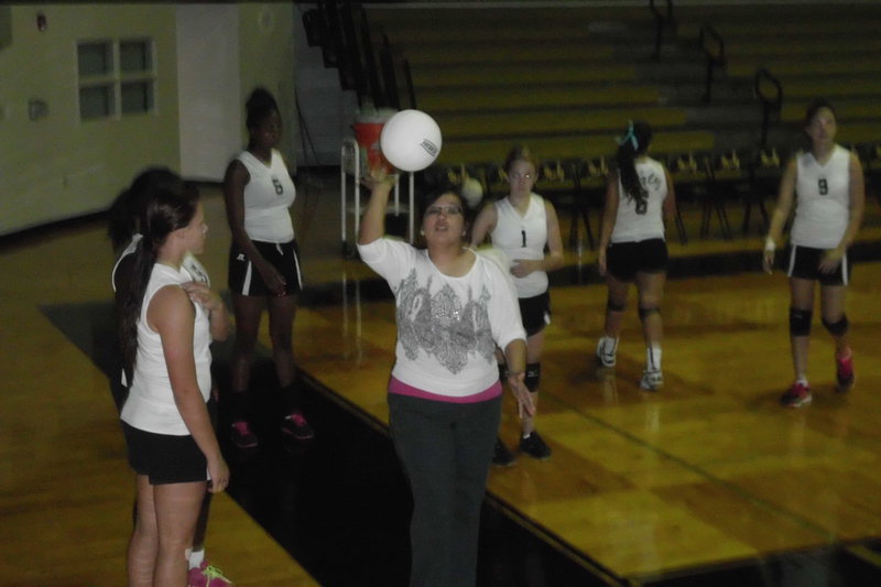 Image: Tina Richards, 9th grade volleyball coach, helps her players with drills before the Mildred game.