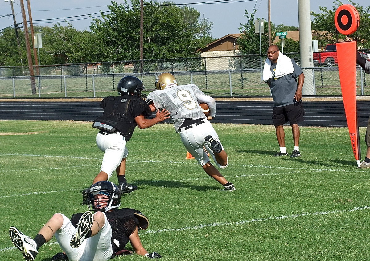 Image: Joe Celis(9) breaks to the outside for a 1st down as Italy assistant coach Larry Mayberry watches closely from the sideline.