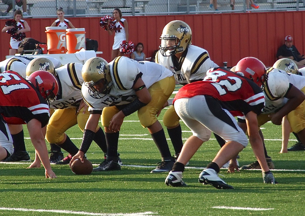 Image: Italy’s JV center David De La Hoya(60) prepares to snap to quarterback Joe Celis(2).