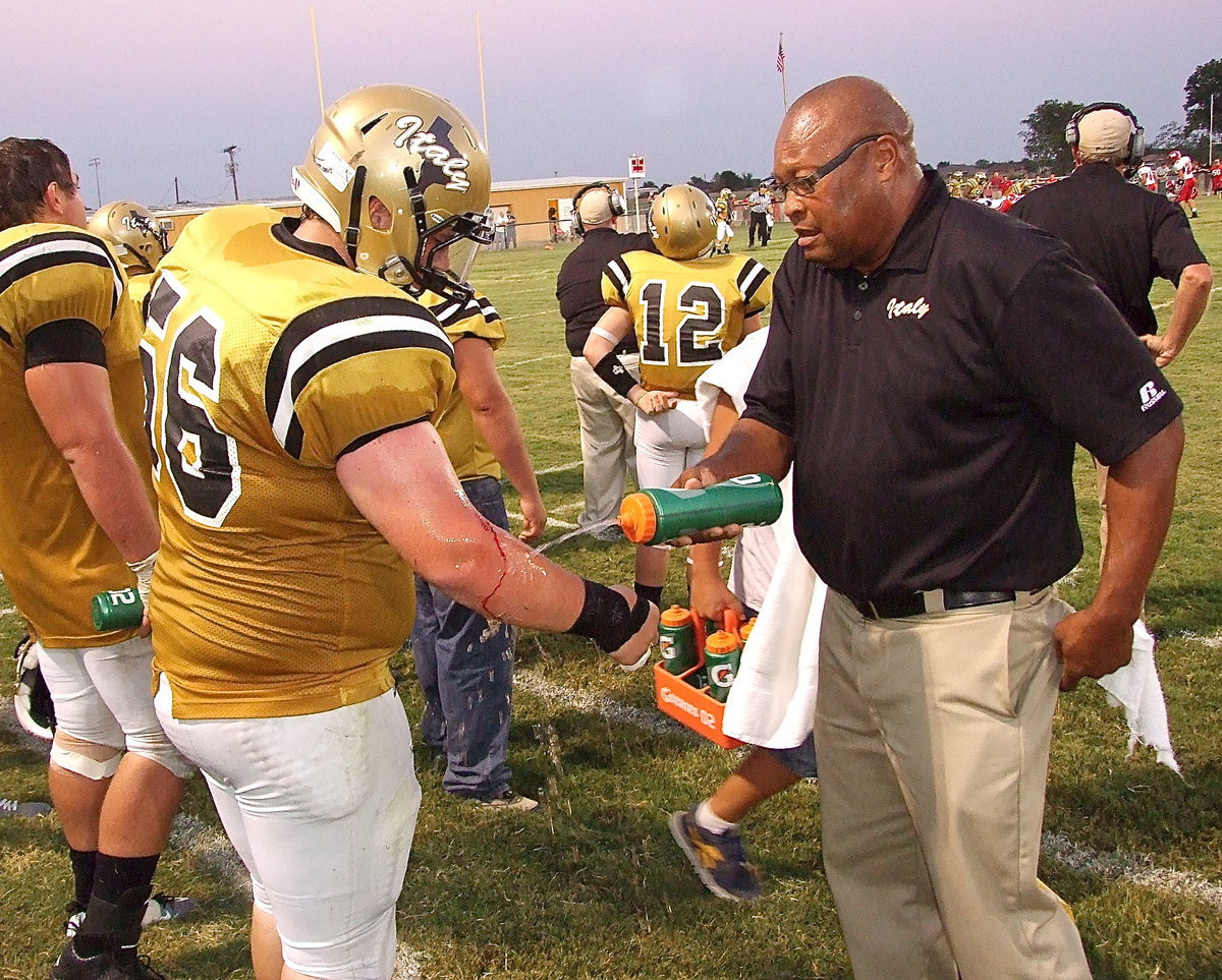 Image: Injured again? John Byers(56) is forced back out of the game with a cut on his arm after returning for one play after having a dislocated finger reset. Assistant coach Larry Mayberry, Sr., acts as the cut man for the king’s of the world.