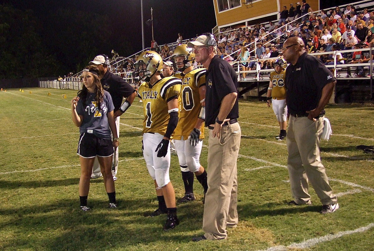 Image: Gladiator first-year head coach Charles Tindol prepares to send Levi McBride(1) in with a play as stat girl Bailey Eubank stays close to the action.