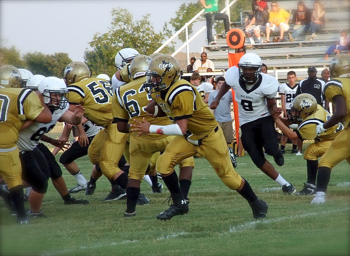 Image: Adrian Acevedo(70), Austin Crawford(56), Kenneth Norwood, Jr.(63) and Dylan McCasland(3) get a push as quarterback Joe Celis(2) finds room to run.