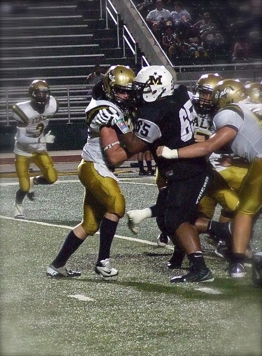 Image: Italy’s junior center Kyle Fortenberry(66) blocks a Tiger tackler away from the hole.