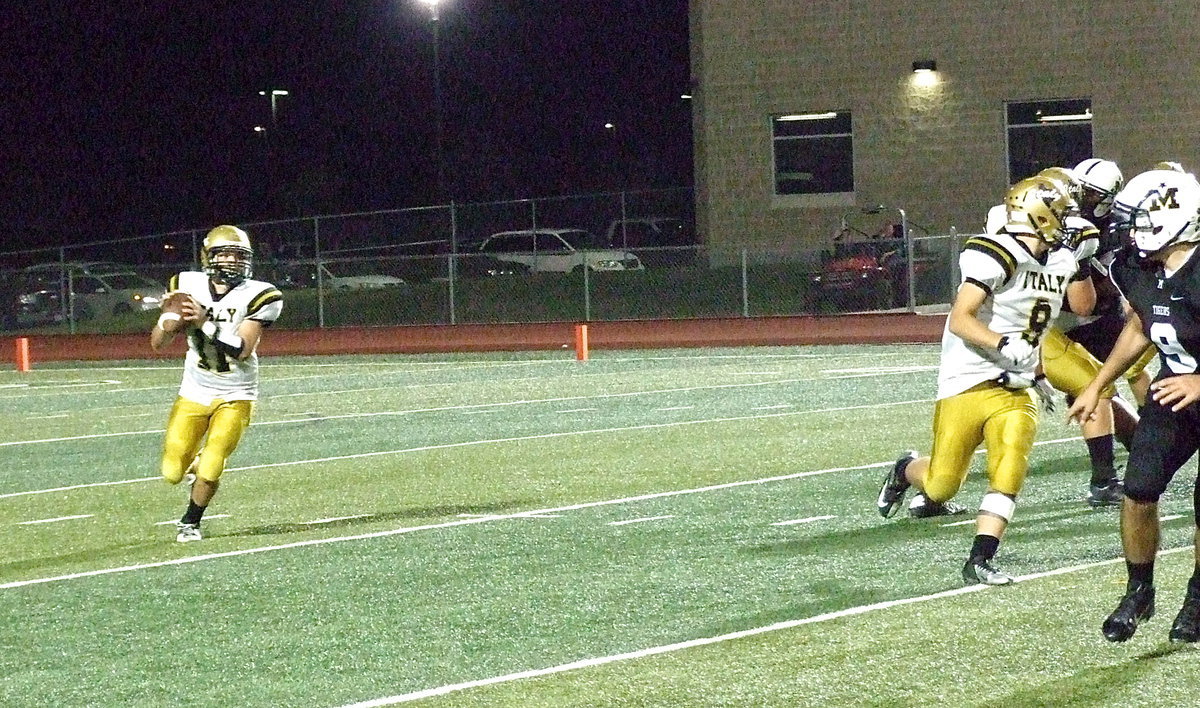 Image: Gladiator quarterback Tyler Anderson(11) rolls out and searches for a receiver with teammate Hunter Merimon(9) offering protection.