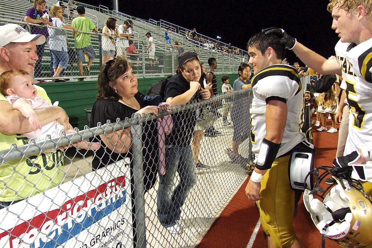 Image: Cody Boyd(15) congratulates Italy quarterback Tyler Anderson(11) on his game efforts as Anderson visits with his proud family.