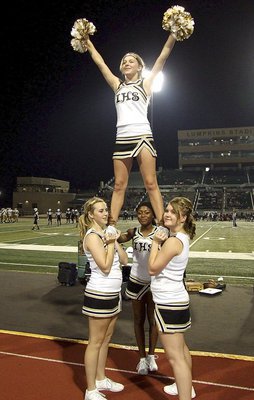 Image: Italy HS cheerleaders Kelsey Nelson, K’Breona Davis and Taylor Turner hoist Britney Chambers high into the Friday night air.
