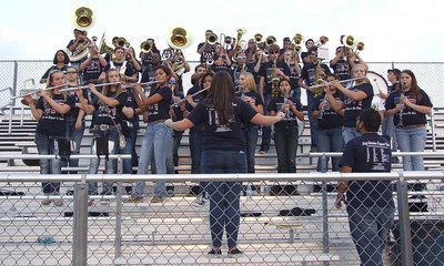Image: The Gladiator Regiment Band and director, Jesus Perez, tune up before the game.