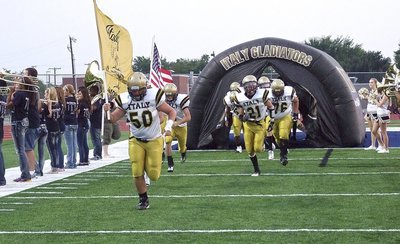 Image: Zain Byers(50) and Justin Wood(4) carry the flags to lead the Gladiators into battle against Sunnyvale as Ryan Connor(21), Colin Newman(76) and the rest of the team burst out of the tunnel.