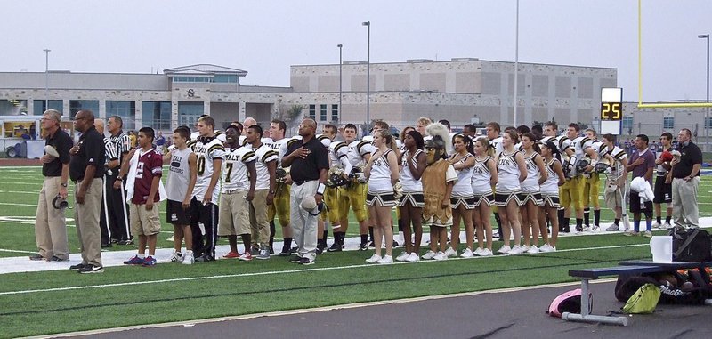 Image: The Gladiator coaches, their players, the cheerleaders and waterboys show respect during the pre-game anthem.