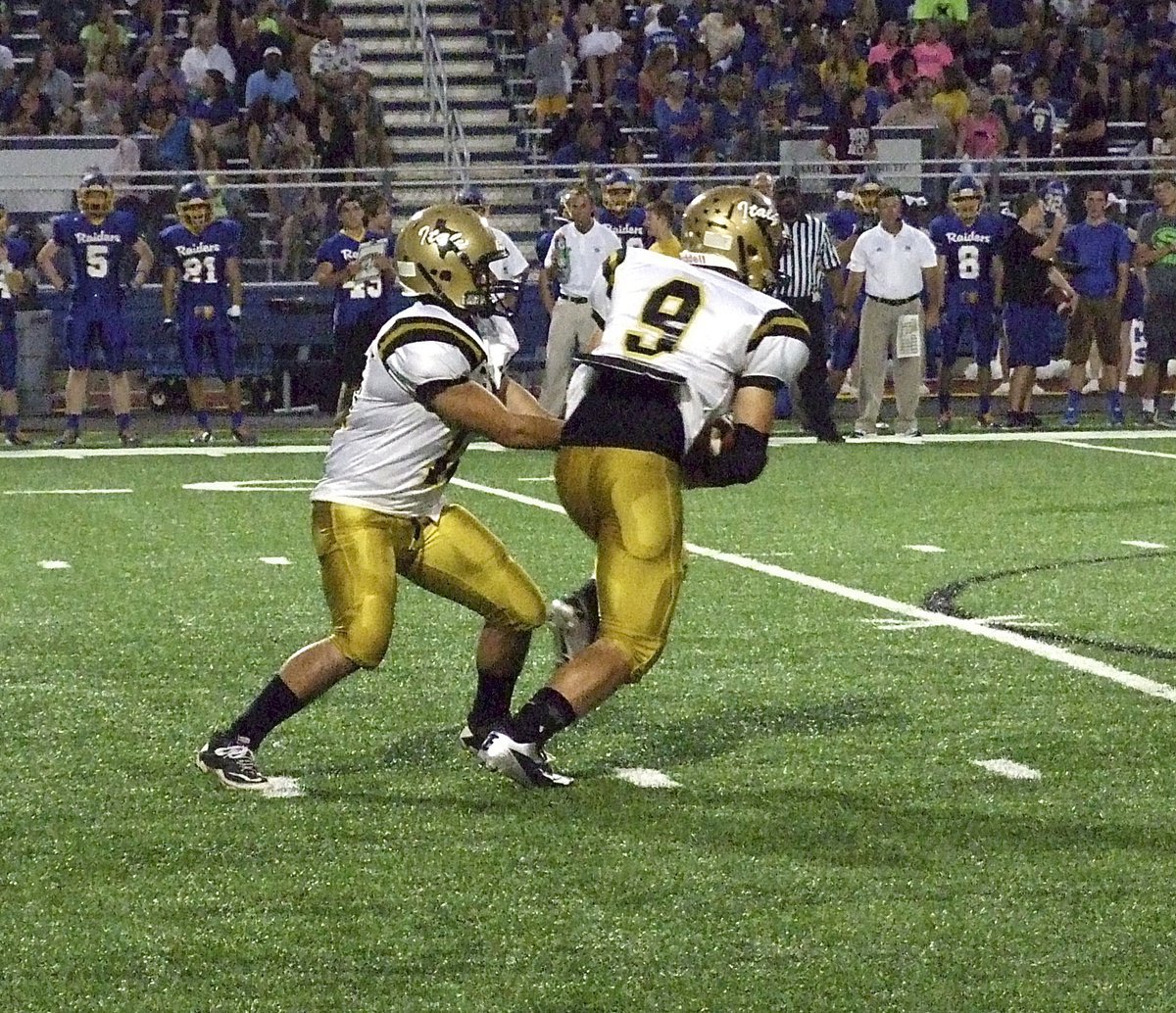 Image: Quarterback Tyler Anderson(11) hands off to sophomore back Hunter Merimon(9).