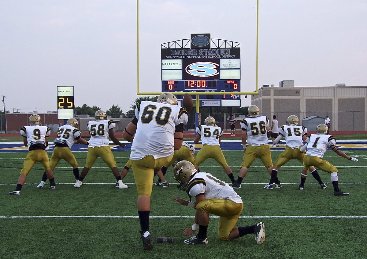 Image: Kevin Roldan(60) practices point-after kicks with teammate Tyler Anderson(11) holding before Italy takes on Sunnyvale.